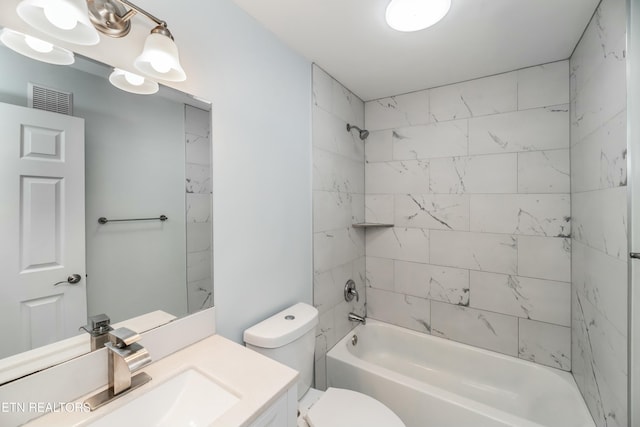 full bathroom featuring tiled shower / bath, vanity, and toilet