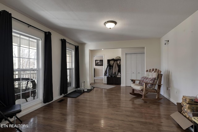 foyer entrance with dark hardwood / wood-style flooring and a textured ceiling