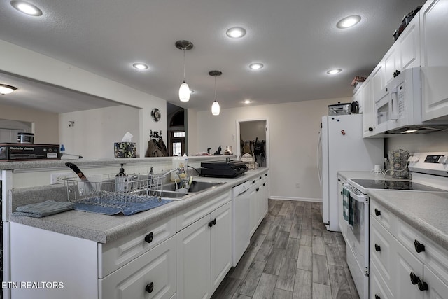 kitchen with pendant lighting, sink, white appliances, and white cabinets