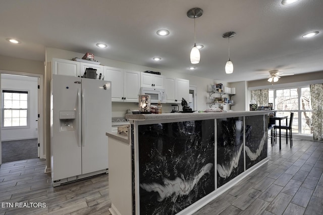 kitchen with white cabinetry, white appliances, a kitchen island, and hanging light fixtures