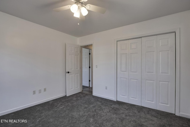 unfurnished bedroom featuring dark colored carpet, ceiling fan, and a closet