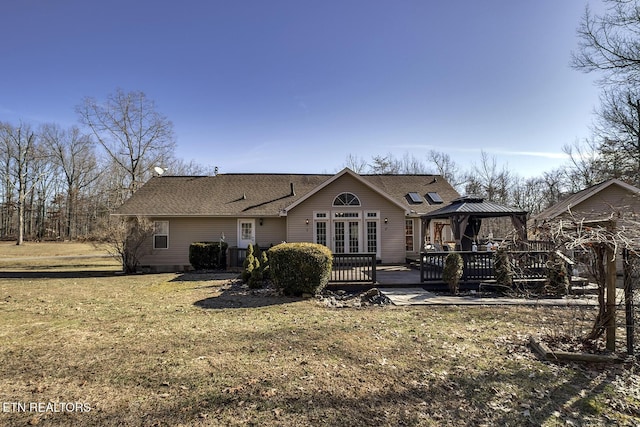 rear view of house with a gazebo, a yard, and a wooden deck