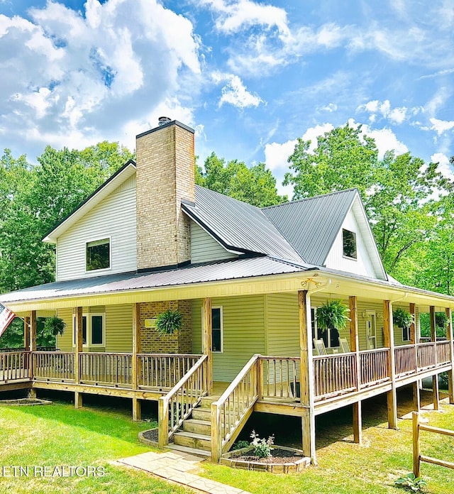 back of property with a yard and covered porch