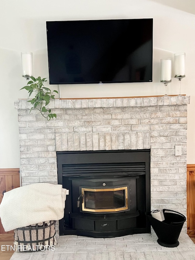 room details with a wainscoted wall and a brick fireplace