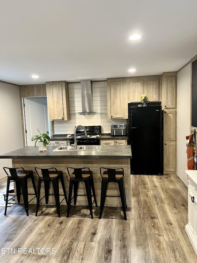 kitchen featuring light wood-type flooring, black appliances, wall chimney exhaust hood, and a kitchen breakfast bar