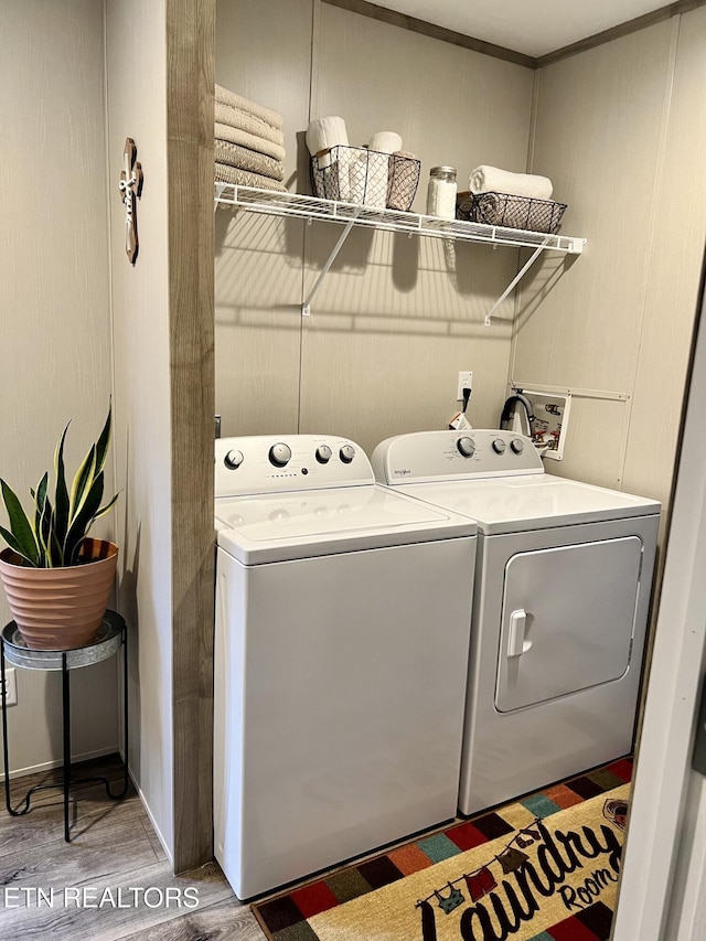 laundry area featuring laundry area, wood finished floors, and independent washer and dryer