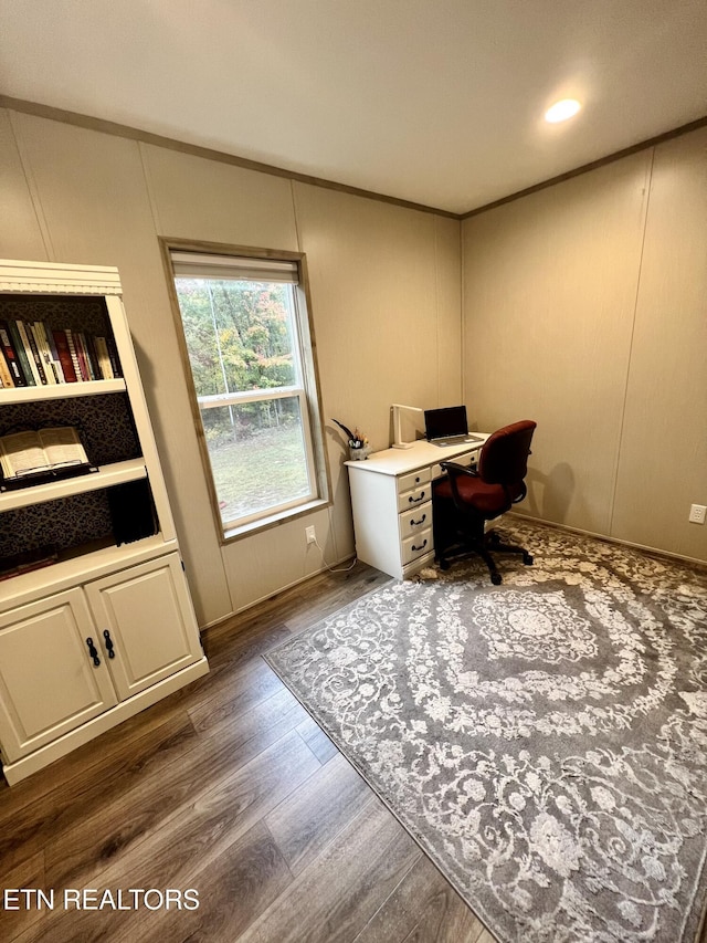 home office featuring crown molding, wood finished floors, and a decorative wall