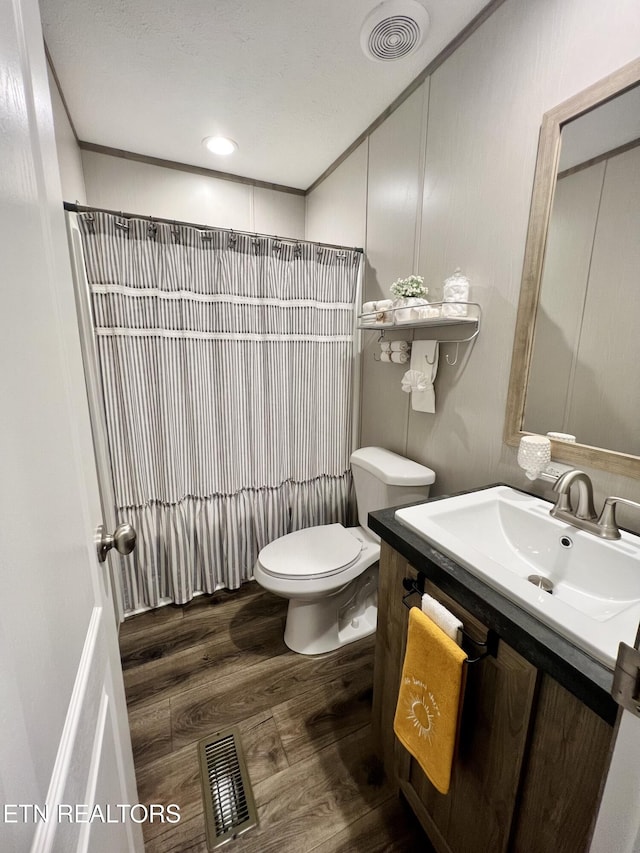 bathroom featuring visible vents, vanity, a shower with shower curtain, and wood finished floors