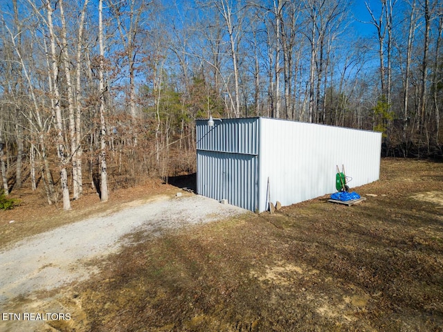 view of outbuilding with dirt driveway and an outbuilding