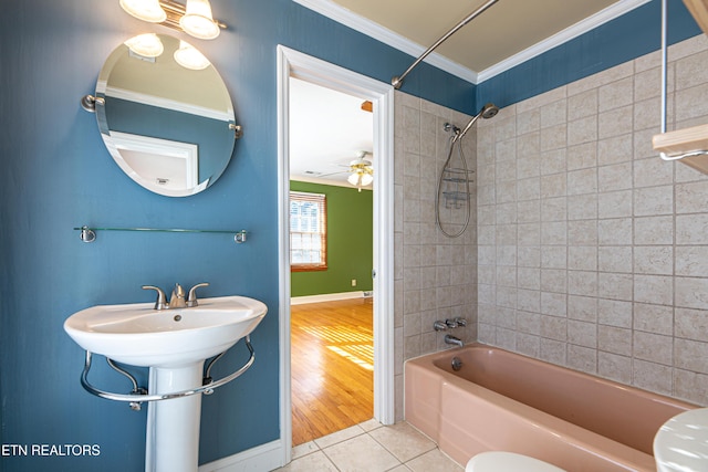 bathroom with crown molding, tiled shower / bath, toilet, and tile patterned flooring