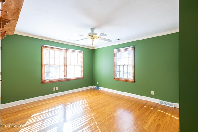 unfurnished room featuring hardwood / wood-style flooring, ornamental molding, and a healthy amount of sunlight