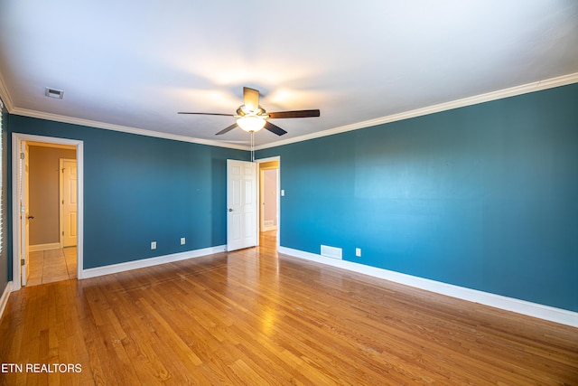 empty room featuring hardwood / wood-style flooring, ceiling fan, and crown molding