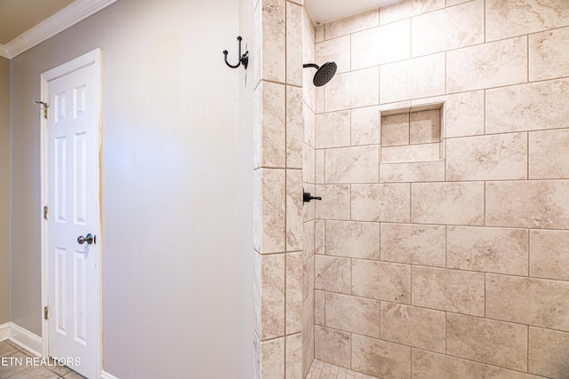 bathroom featuring a tile shower and ornamental molding