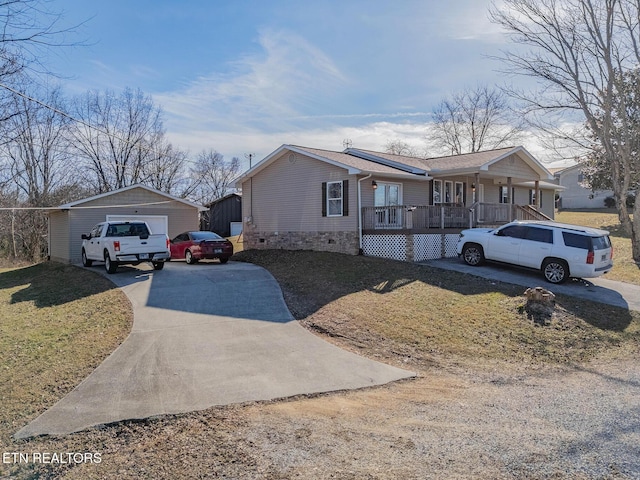 view of front of property featuring a garage, an outdoor structure, a front yard, and covered porch