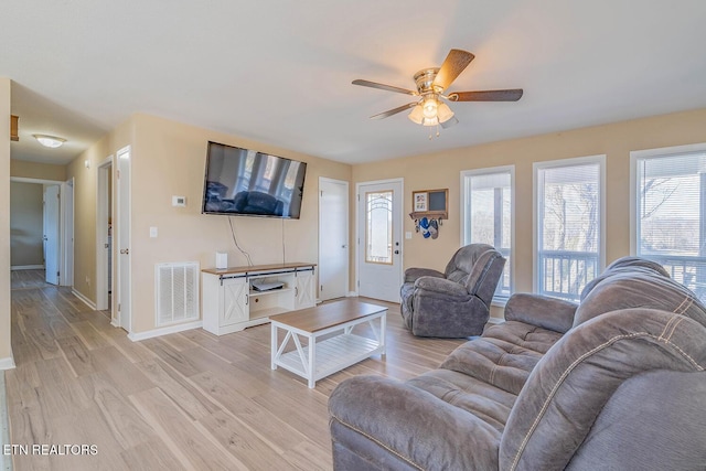 living room with ceiling fan and light hardwood / wood-style flooring