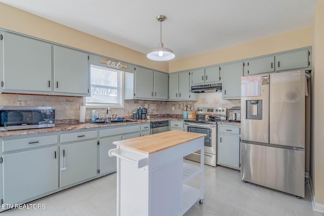 kitchen featuring pendant lighting, stainless steel appliances, sink, and backsplash