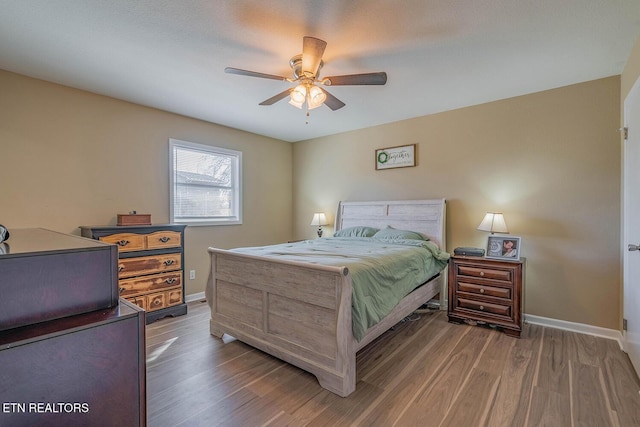 bedroom with dark hardwood / wood-style flooring and ceiling fan