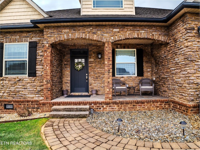 view of exterior entry featuring covered porch