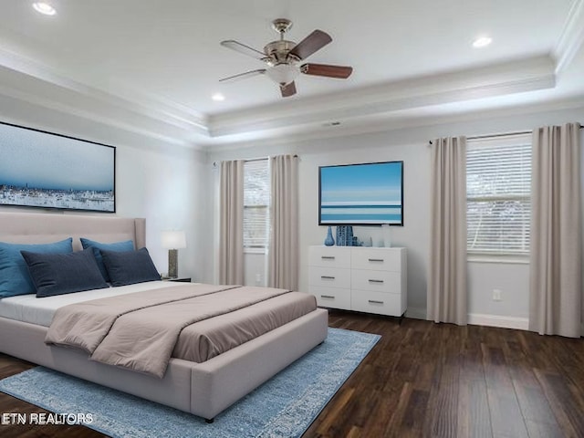 bedroom featuring a raised ceiling, dark wood-style flooring, recessed lighting, baseboards, and crown molding