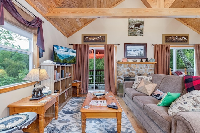 living room with hardwood / wood-style floors, high vaulted ceiling, a stone fireplace, wooden ceiling, and beamed ceiling