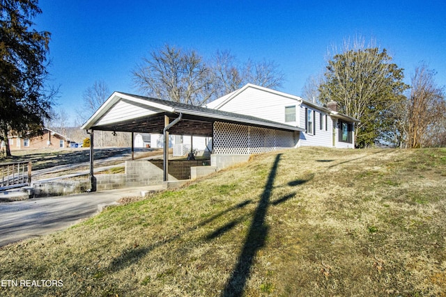 view of home's exterior featuring a carport and a lawn