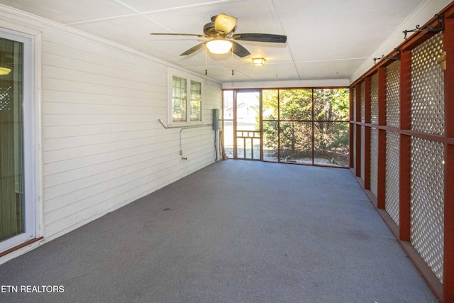 unfurnished sunroom with ceiling fan