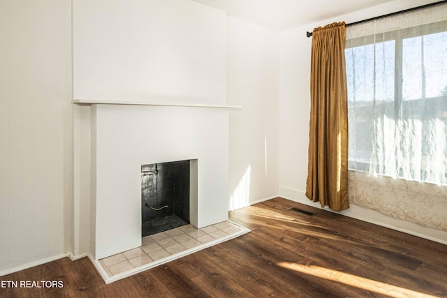 room details with a tiled fireplace and wood-type flooring