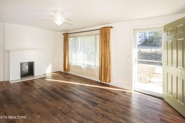 unfurnished living room featuring dark hardwood / wood-style flooring and ceiling fan