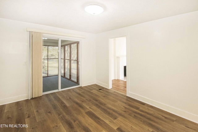 spare room with dark wood-type flooring