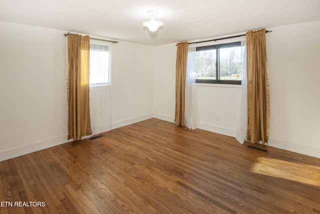 spare room featuring hardwood / wood-style floors and a healthy amount of sunlight