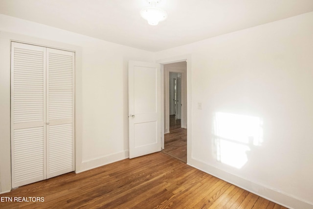 unfurnished bedroom with wood-type flooring and a closet