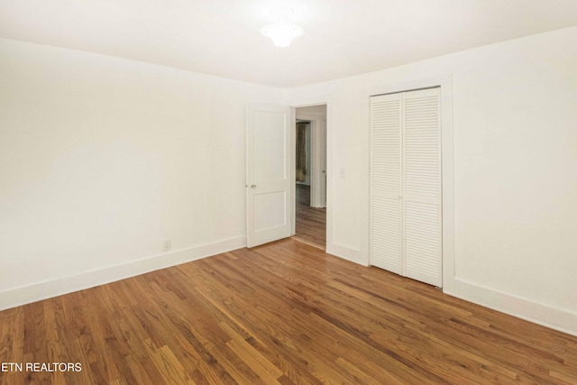 unfurnished bedroom with hardwood / wood-style flooring and a closet