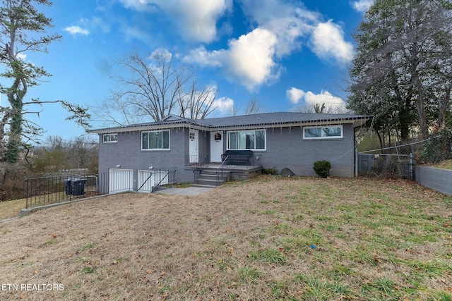 ranch-style home featuring cooling unit and a front yard