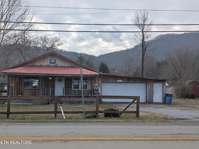 view of front of house with a garage, a mountain view, and covered porch