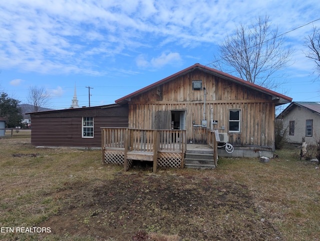 view of front of home with a deck and a front yard