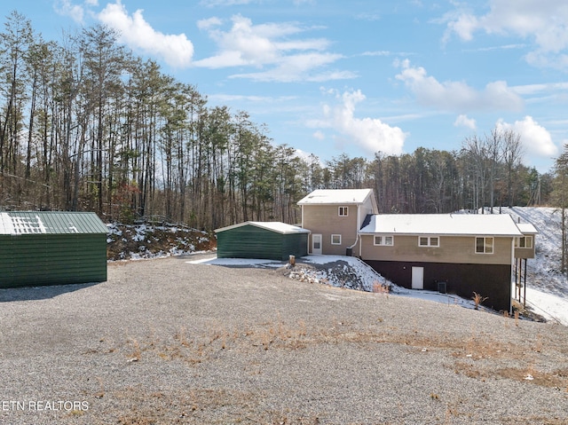 back of house featuring a carport