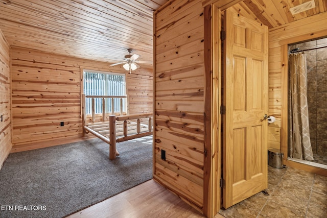 hall featuring wood ceiling and wood walls