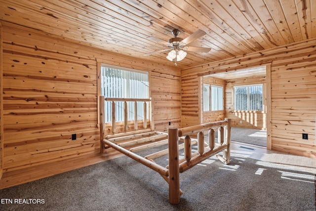 bedroom featuring carpet flooring, wooden ceiling, and wooden walls