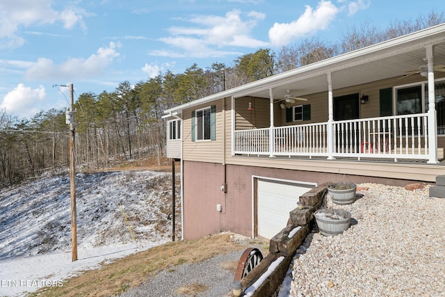 view of side of home with ceiling fan and a garage