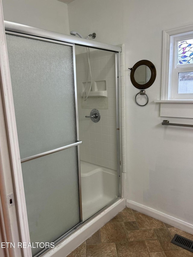 bathroom with a shower with shower door