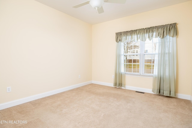 carpeted spare room featuring ceiling fan