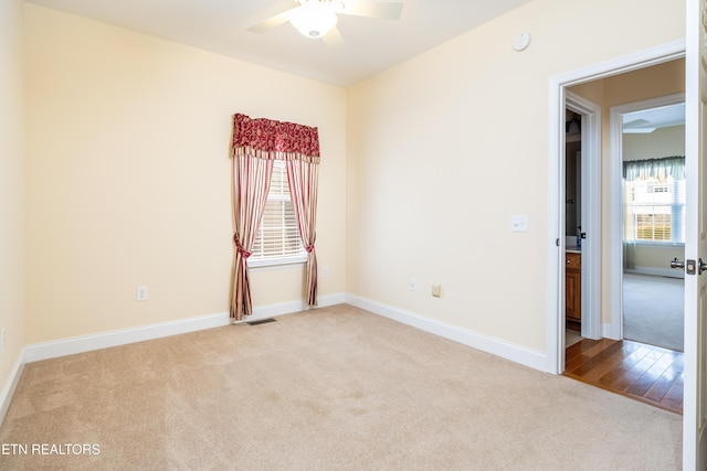 carpeted empty room with a wealth of natural light and ceiling fan