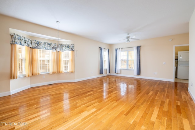 unfurnished room with ceiling fan with notable chandelier and hardwood / wood-style floors