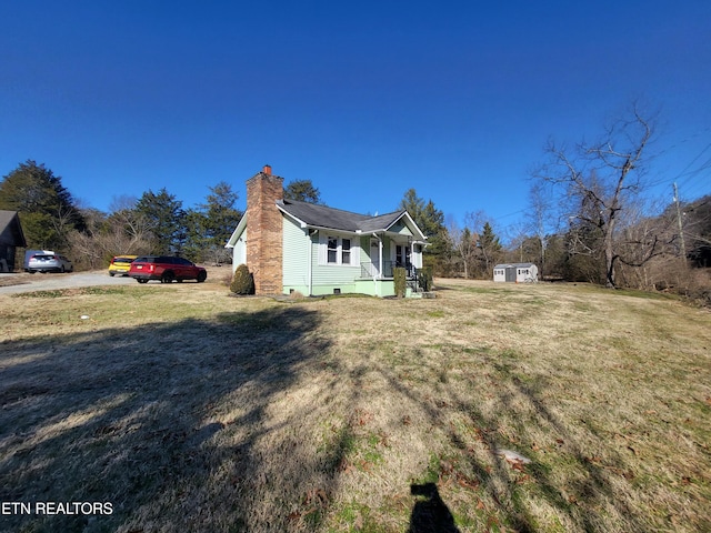 view of property exterior featuring a porch, a yard, and a storage shed