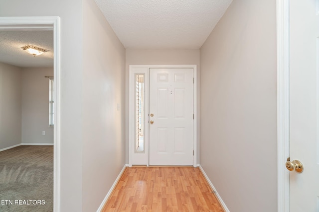 entryway featuring a textured ceiling and light hardwood / wood-style flooring