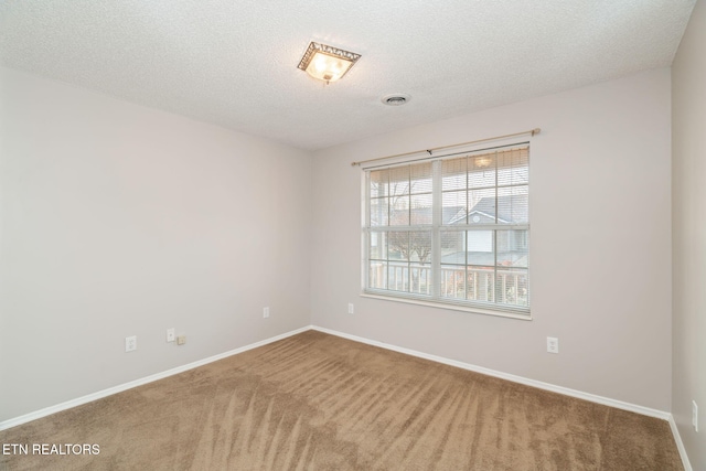 carpeted empty room with a textured ceiling