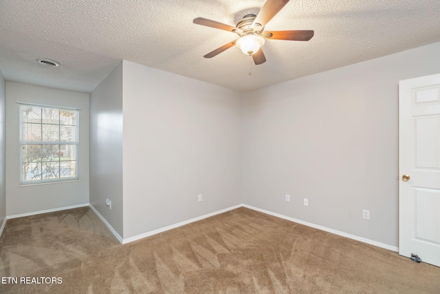 carpeted spare room featuring a textured ceiling and ceiling fan