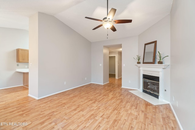 unfurnished living room featuring ceiling fan, lofted ceiling, and light wood-type flooring