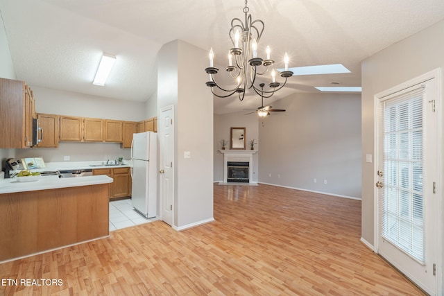 kitchen featuring pendant lighting, lofted ceiling, white fridge, range, and ceiling fan