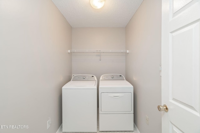 clothes washing area with a textured ceiling and independent washer and dryer